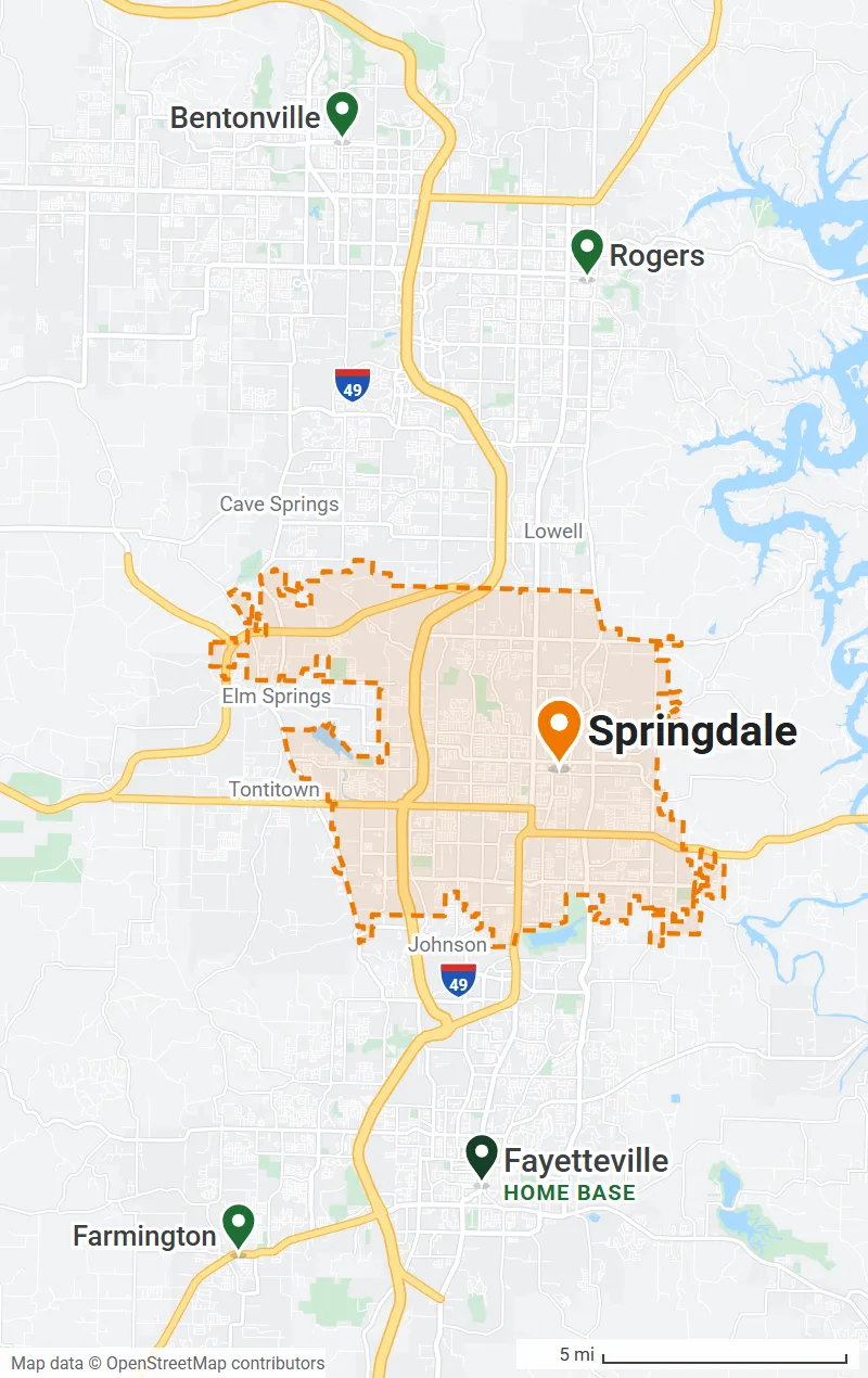 Map of Northwest Arkansas with the Springdale city limits outlined in orange and pins on Bentonville, Rogers, Fayetteville (home base) and Farmington, with I-49 running through all of them